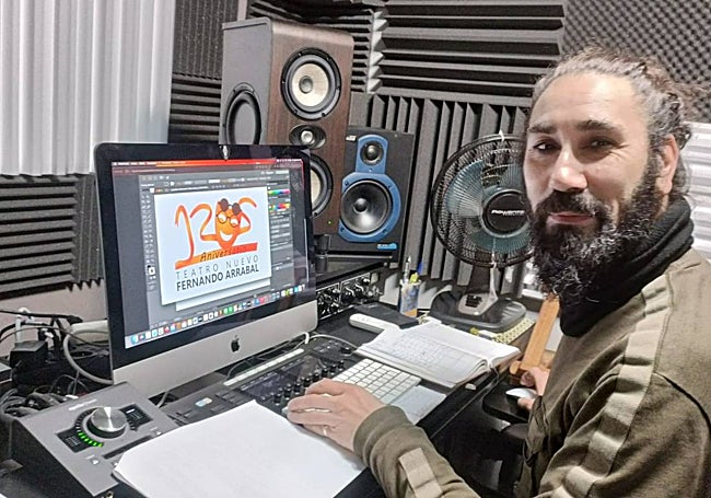 Sergio Cardoso en su estudio con el logotipo creado de fondo.