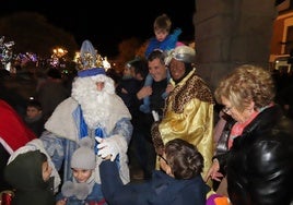 Melchor y Baltasar saludan a los niños al bajar de sus carrozas