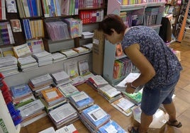 Una librería prepara diferentes paquetes de libros de texto para entregar a los colegios.