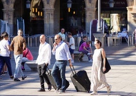 Varios turistas pasean por la Plaza Mayor.