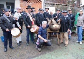 Colaboradores, autoridades y tamborileros junto al cerdo