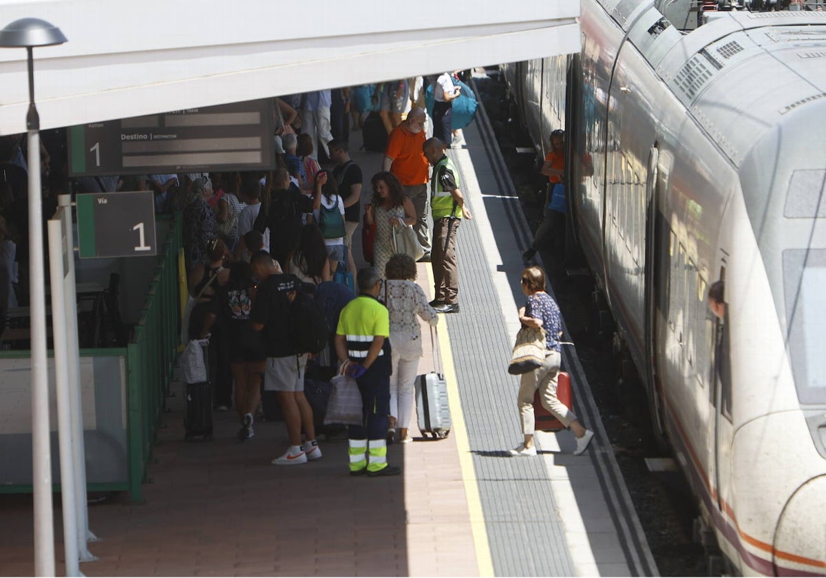 Viajeros bajando del tren en la estación de trenes.