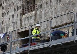 Trabajadores de la construcción, en la fachada de un edifico de la ciudad.