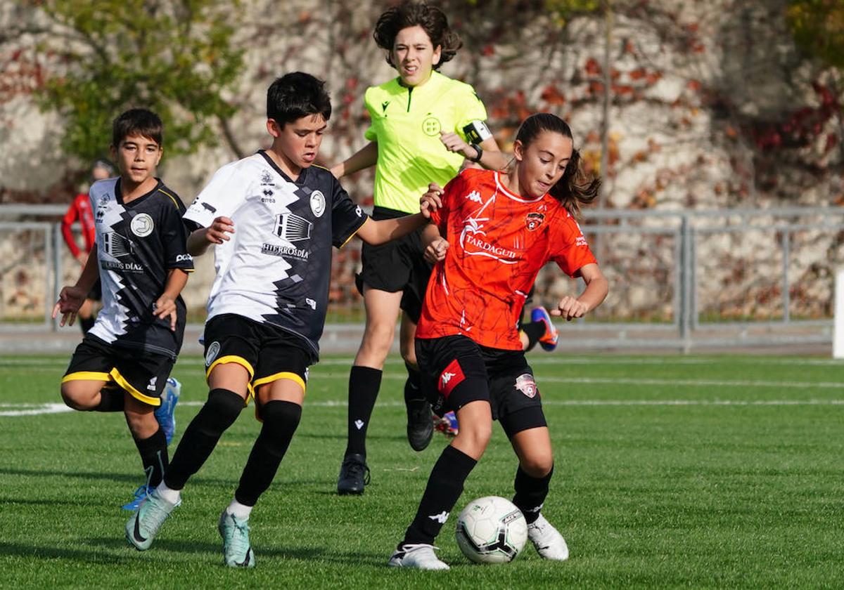 Una jugadora del Salamanca FF y un jugador de Unionistas pugnan por el control del balón durante un partido de la Segunda División alevín en el Vicente del Bosque.