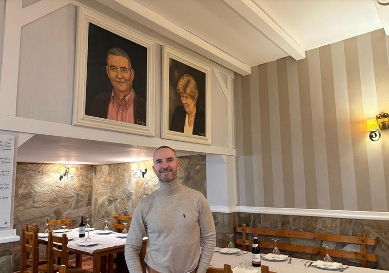 José Javier García en su restaurante de la calle Cortes de Cádiz frente a los retratos de sus padres que cuelgan en el local.