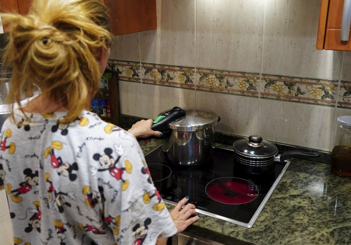 Una mujer prepara la comida en una placa de inducción.