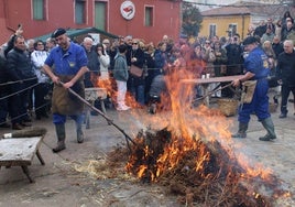 Chamuscado del cerdo ante la atenta mirada del público congregado en la plaza de Castilla y León