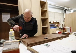 Un carpintero perforando un tablón de madera