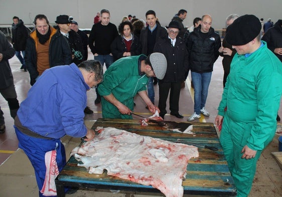 Despiece del cerdo en el interior del pabellón ante la atenta mirada de vecinos y visitantes