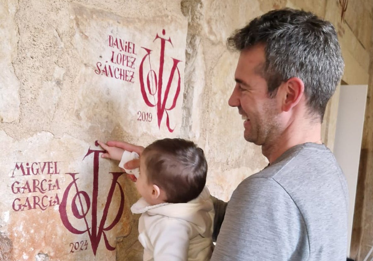 El bebé de Miguel García, restaurador de obras de arte y pintor de vítores, toca el vítor honorífico de su padre, doctor por la Universidad de Salamanca.