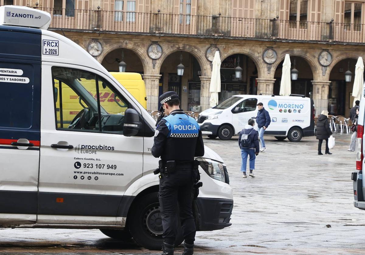 Un agente de la Policía Local vigila en la Plaza Mayor los vehículos de carga y descarga.