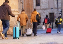 Jóvenes con maletas por el centro de la ciudad.