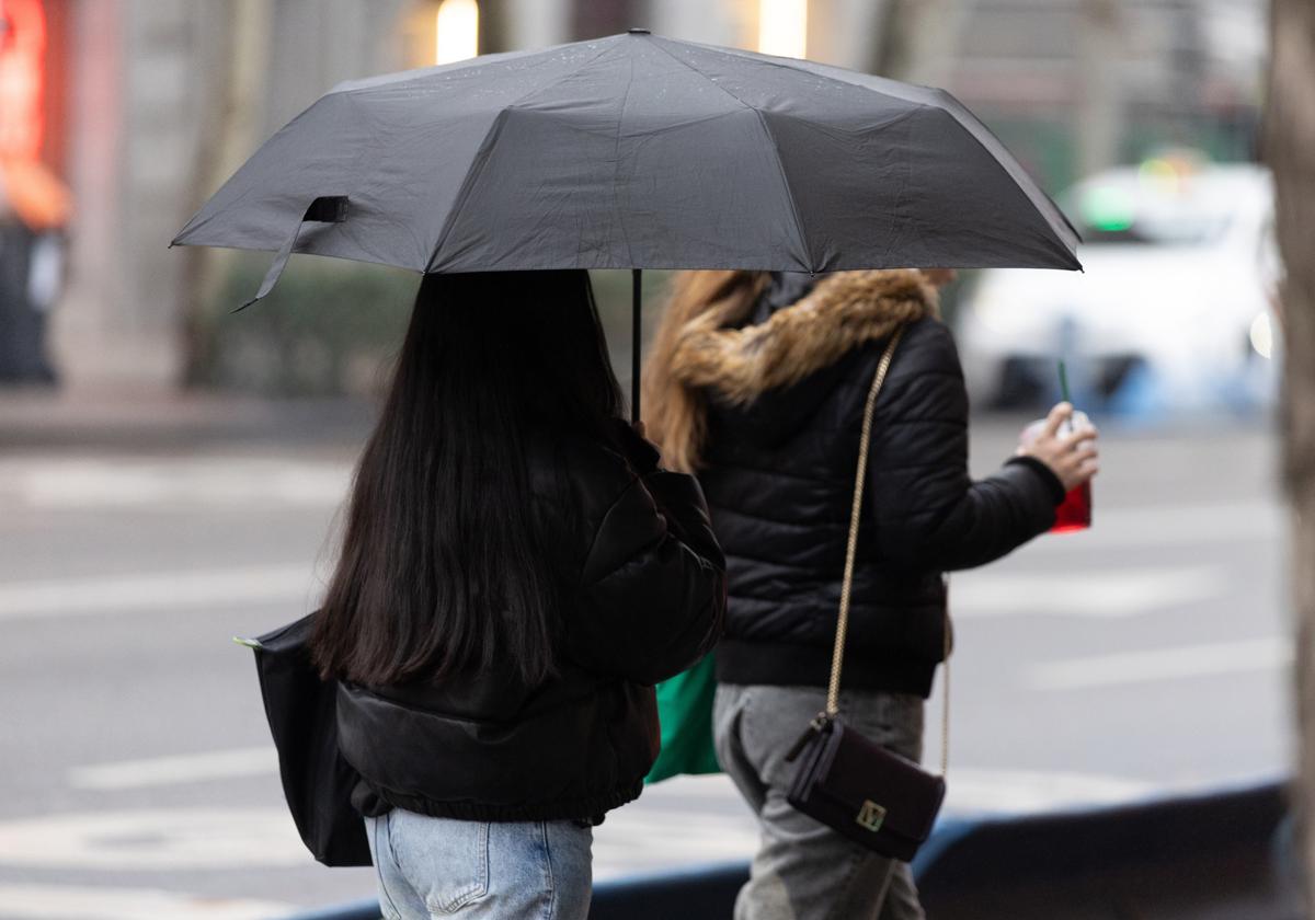 Dos mujeres se protegen de la lluvia.