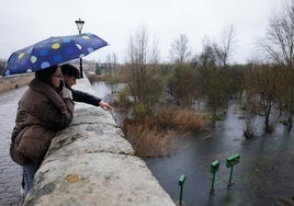 Una pareja observa el caudal del Tormes desde el Puente Romano.