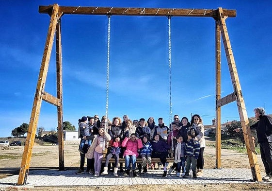 Un grupo compuesto por adultos y niños disfruta del columpio ubicado en Los Pilones, en Juzbado.
