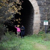 Dos turistas saliendo de uno de los túneles de la ruta