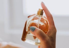 Mujer con un perfume en su mano.