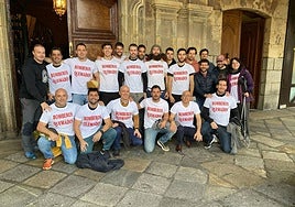 Bomberos en la puerta de salón de plenos con camisetas de 'Bomberos quemados', este viernes.
