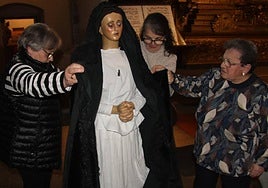 Esther Hernández, Rosa Hernández y Chari Hernández en los primeros pasos para vestir a La Soledad.