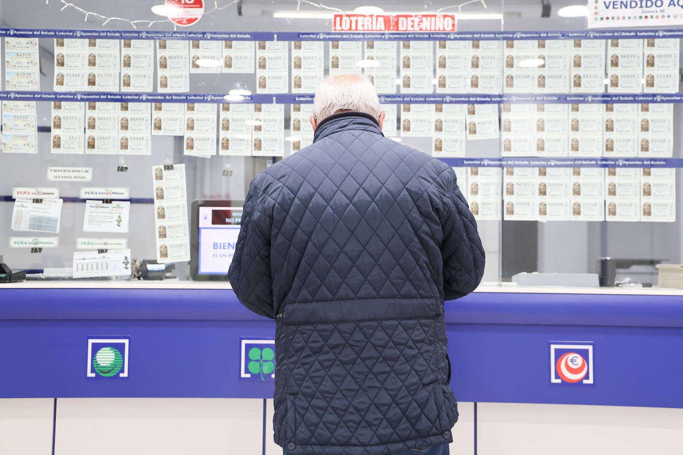 Un salmantino, comprando un boleto de lotería en una administración de la capital.