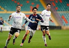Casado y Murua tratan de detener a un jugador del filial deportivista en el encuentro de la primera vuelta.