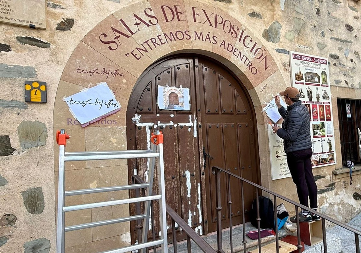 El artista Miguel García durante su trabajo en el arco de piedra de Villamayor con las firmas y el poema.