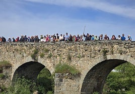 Los asistentes, sobre el puente, disfrutando del río Sangusín