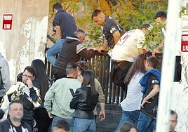 Aficionados saltando la puerta del acceso oeste al estadio.