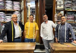 José Manuel Mulas Fernández (i), sus dos hijos y el empleado, tras el mostrador de Pañerías Fernández.