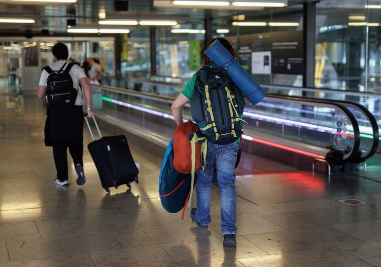 Dos personas con equipaje en la terminal T4 del Aeropuerto Adolfo Suárez Madrid-Barajas.
