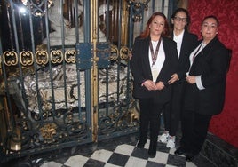 Un grupo de voluntarias ante el sepulcro de Santa Teresa de Jesús y la urna de plata.