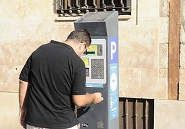 Un usuario de la ORA saca su ticket de aparcamiento.