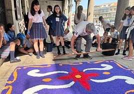 Escolares de quinto de primaria del colegio Nuestra Señora del Castañar elaborando este domingo las alfombras.