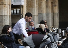 Un camarero atendiendo una terraza de la Plaza Mayor.