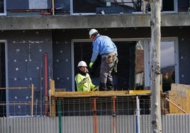Dos obreros de la construcción trabajando en un edificio.