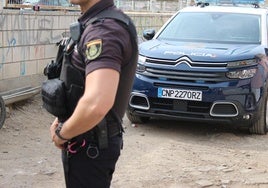 Imagen de un agente de la Policía Nacional delante de su vehículo.