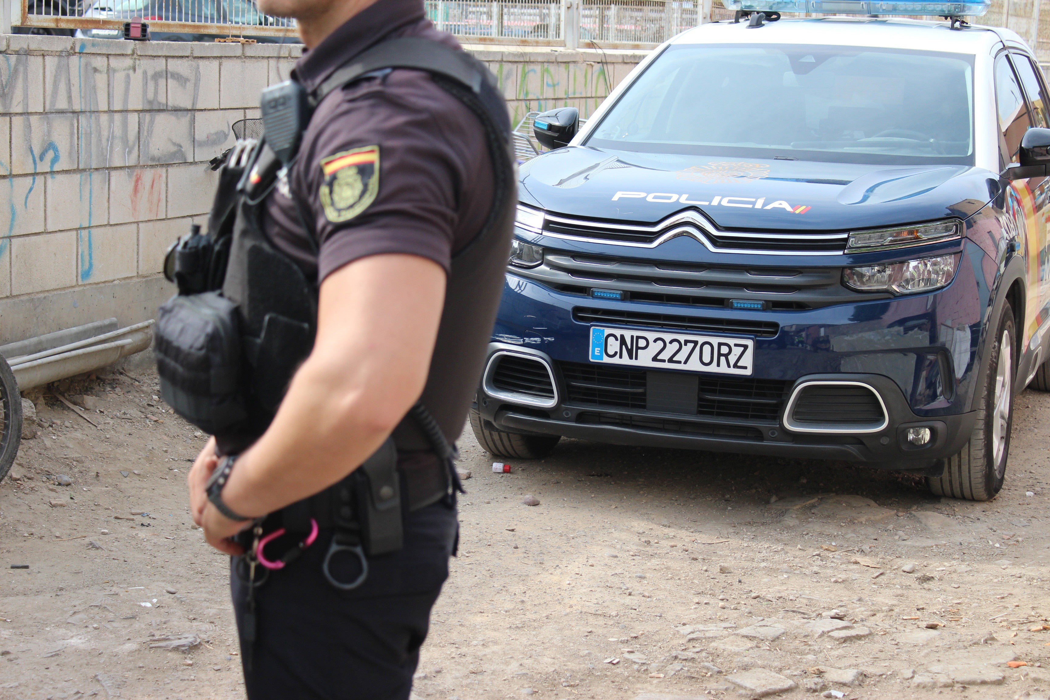 Imagen de un agente de la Policía Nacional delante de su vehículo.