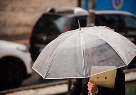 Una mujer se protege de la intensa tormenta.