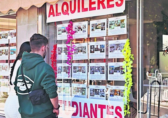 Dos jóvenes mirando pisos en alquiler.