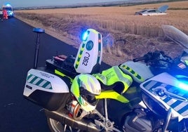 Imagen de una moto de la Guardia Civil, con el vehículo de fondo.