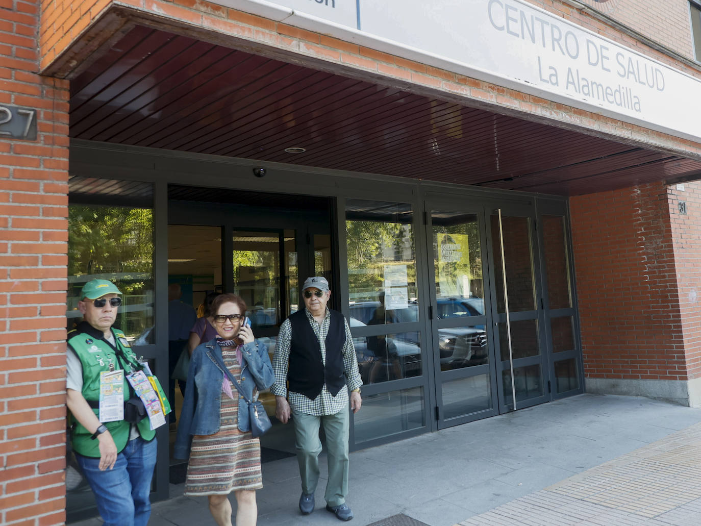 Dos personas salen del centro de salud de La Alamedilla.