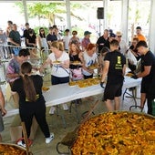 Los vecinos de Tejares recogiendo sus raciones de paella.