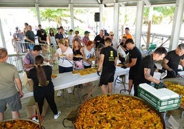 Los vecinos de Tejares recogiendo sus raciones de paella.