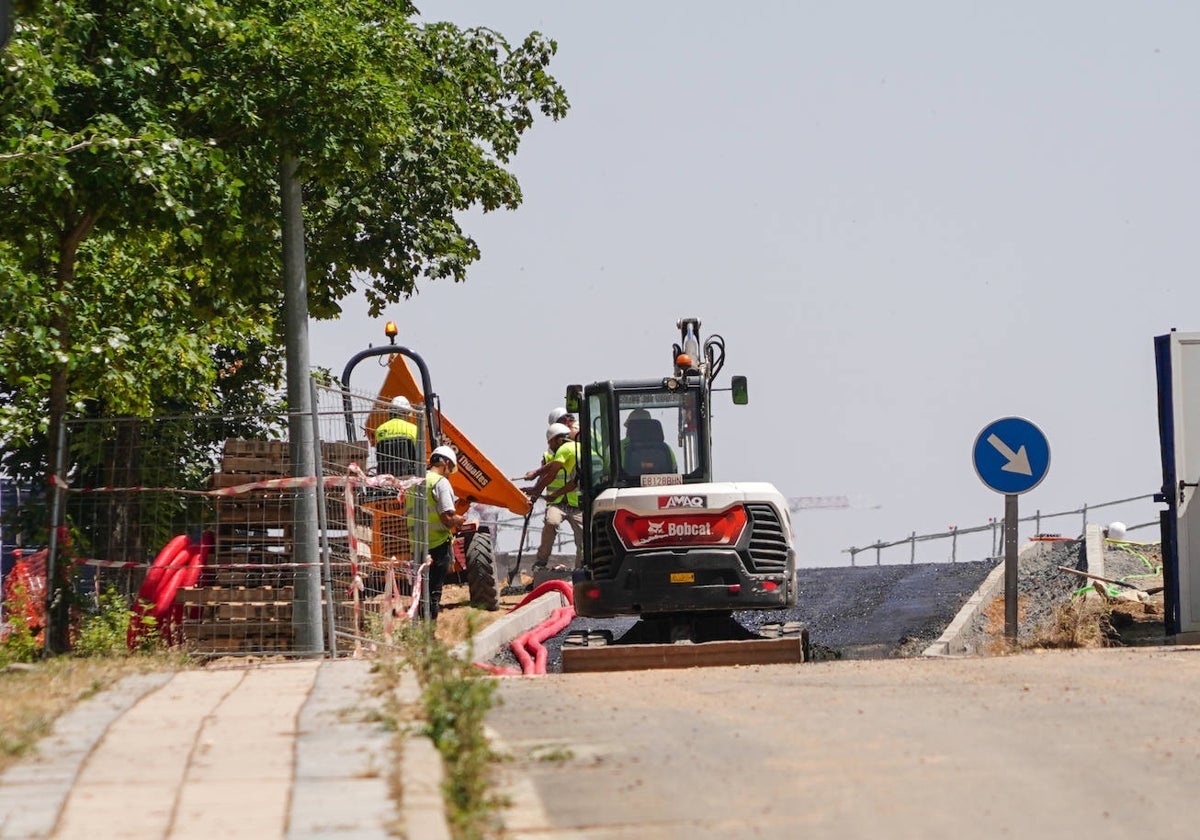Trabajadores de la empresa que asume la obra de Adif, en las tareas de asfaltado de la vía.