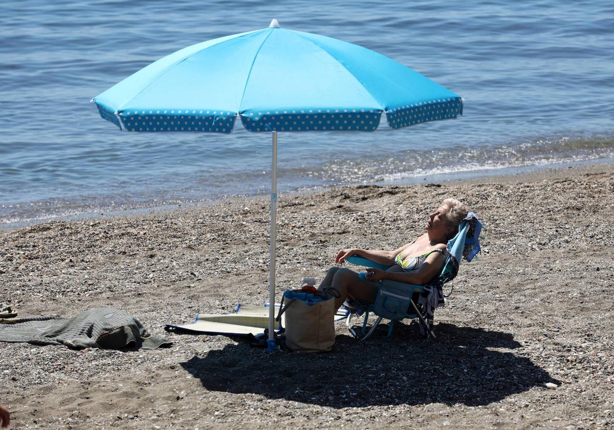Una mujer toma el sol en una playa.