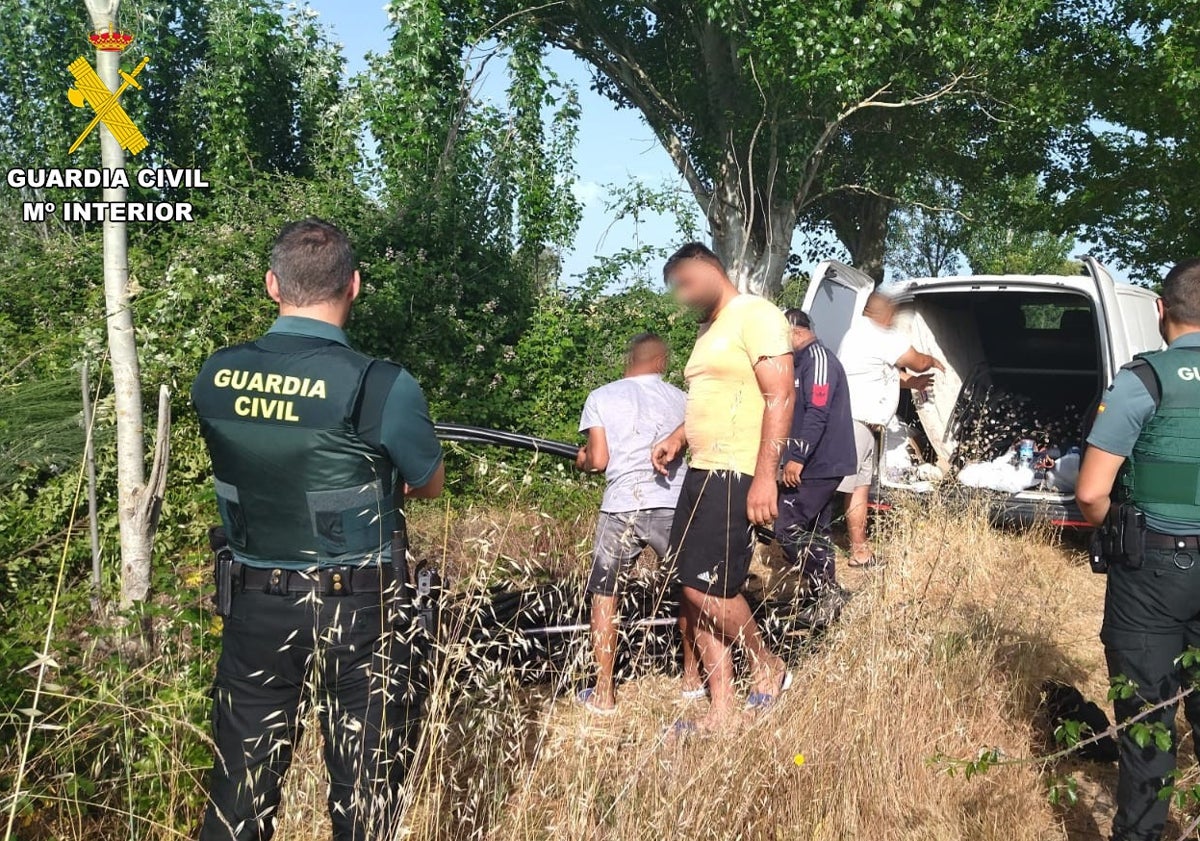 Imagen principal - Agentes de la Guardia Civil junto a los detenidos y la furgoneta llena de cableado de cobre intervenido.