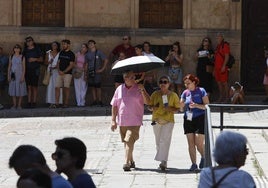 Dos turistas y una guía, bajo el sol en el casco histórico de Salamanca.