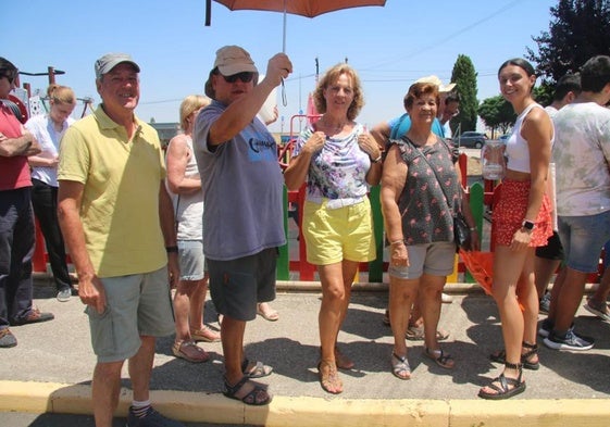 Un grupo de vecinos de Pelabravo, en la cola de la parrillada con la sombrilla.