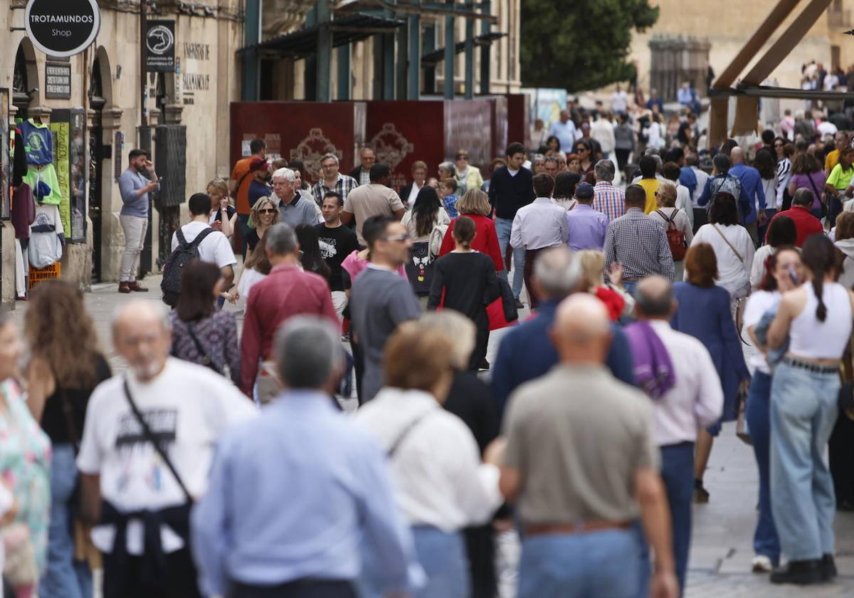Salmantinos y turistas, paseando por una calle del centro de Salamanca.