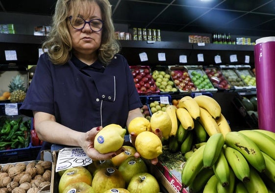 Una frutera del Mercado Central, escogiendo unos limones.